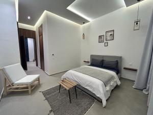 1 dormitorio con 1 cama y 1 silla en Villa ISSA en Marrakech