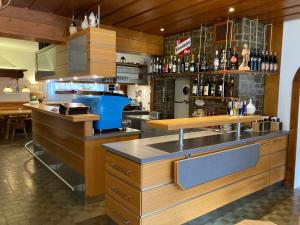 a kitchen with a counter and a bar with bottles at Gasthof Paluda - Pizzeria in Dalaas