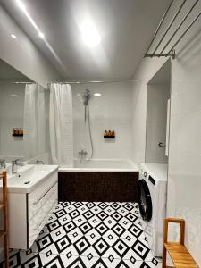 a bathroom with a shower and a sink and a washing machine at Luxury 3 bedroom apartment near Schönbrunn Palace in Vienna