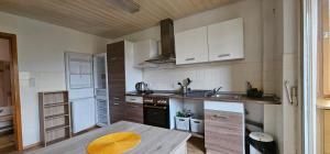a kitchen with white cabinets and a wooden table at Monteurwohnung/Ferienwohnung an der Steige in Geislingen an der Steige +6 photos