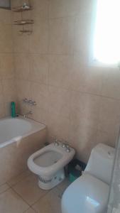 a bathroom with a toilet and a bidet and a bath tub at La Apacheta in San Roque