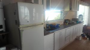 a kitchen with a white refrigerator and a sink at La Apacheta in San Roque