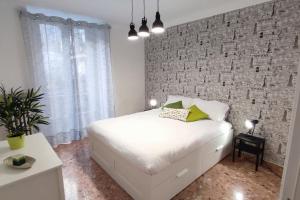 a bedroom with a white bed and a brick wall at Nel cuore di Torino in Turin