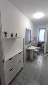 a white bathroom with two toilets and a sink at Nel cuore di Torino in Turin