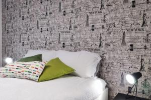 a bedroom with a white bed with aastered wall at Nel cuore di Torino in Turin