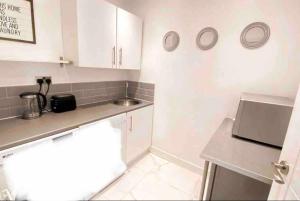 a small kitchen with white cabinets and a counter top at Luxury studio apartment, Beckenham in Elmers End