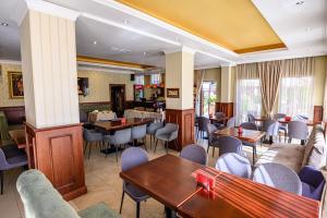 a restaurant with tables and chairs and a bar at Aquilon Hotel & Thermal Pools in Banya