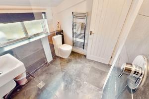 a bathroom with a toilet and a sink at Georgeham Sweet Pea Cottage in Georgeham +38 photos