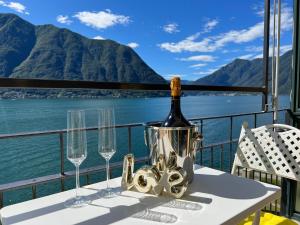 a bottle of wine on a table with wine glasses at Lake Loft Colonno in Colonno