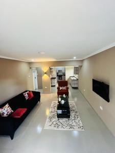 ein großes Wohnzimmer mit einem Sofa und einem Stuhl in der Unterkunft Goldland Apartments Annex in Kitwe