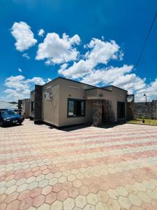 ein Haus mit einem davor geparkt in der Unterkunft Goldland Apartments Annex in Kitwe