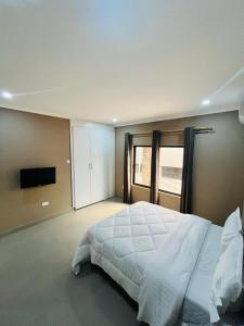 a large bedroom with a large bed and a television at Goldland Apartments Annex in Kitwe