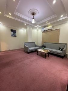 a large room with two couches and a table in it at الفخامة الجنوبية للشقق المخدومة in Jazan