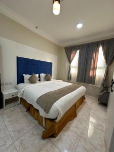 um quarto com uma cama grande e uma cabeceira azul em الفخامة الجنوبية للشقق المخدومة em Jazan