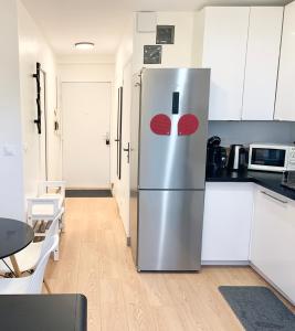 een roestvrijstalen koelkast in een keuken met witte kasten bij Paris 15th near Eiffel Tower in Parijs