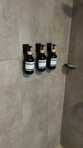 tres botellas de jabón sentadas en un estante en una ducha en Depto Lujo 1D Vista Privilegiada, en Santa Cruz de la Sierra