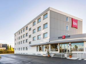 a large white building with a big sign on it at ibis Tarbes Odos in Odos