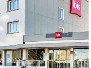 Odosにあるibis Tarbes Odosの建物横の赤い看板の高層店