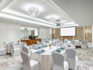 uma sala de conferências com mesas brancas e cadeiras brancas em Sofitel Dubai Jumeirah Beach em Dubai