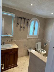 a bathroom with a sink and a toilet and a window at Preciosa casa adosada en Mijas in Mijas
