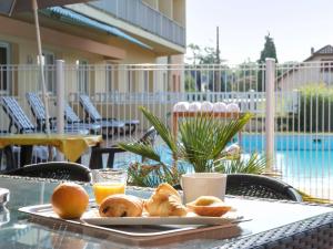 uma bandeja de pão e sumo de laranja numa mesa em ibis Tarbes Odos em Odos