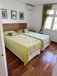 2 camas en un dormitorio con suelo de madera en Preciosa casa adosada en Mijas en Mijas