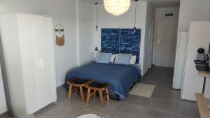 a bedroom with a blue bed and two chairs at Loft La Cala de Mijas beach estudio mirando al mar in La Cala de Mijas