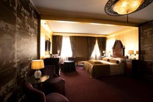 ヴェネツィアにあるHotel Metropole Veneziaのベッド2台とソファが備わるホテルルームです。