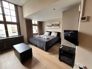 a bedroom with a bed and a flat screen tv at Amazing Studio S3, City Centre Dordrecht in Dordrecht