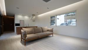 a living room with a couch and a kitchen at Byeonsan Stay 365 in Buan