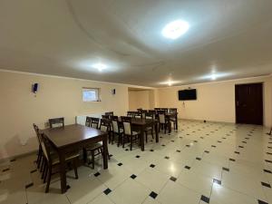 a dining room with tables and chairs and a tv at VerhoVilla in Verkhovyna
