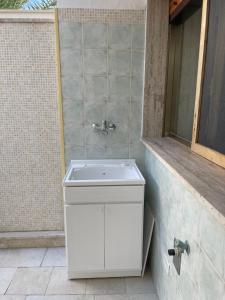 een badkamer met een witte wastafel en een douche bij Piacentini - Locazione turistica - San Pietro in Bevagna in San Pietro in Bevagna