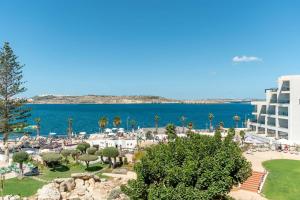 Blick auf ein Resort mit dem Meer im Hintergrund in der Unterkunft DoubleTree by Hilton Malta in St Paul's Bay
