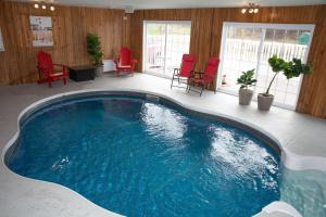 a large swimming pool in a room with red chairs at Travelodge by Wyndham Roberval in Roberval