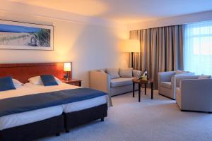 a hotel room with a bed and a couch at Grand Lubicz Uzdrowisko Ustka in Ustka