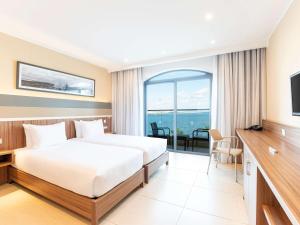 a hotel room with a bed and a view of the ocean at DoubleTree by Hilton Malta in St Paul's Bay