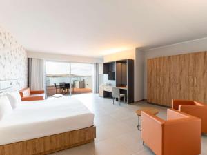 a hotel room with a bed and a living room at DoubleTree by Hilton Malta in St Paul's Bay