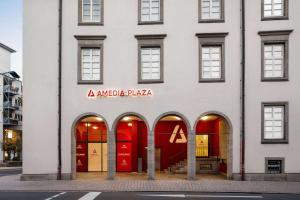 a large white building with red doors at Amedia Plaza Speyer, Trademark Collection by Wyndham in Speyer