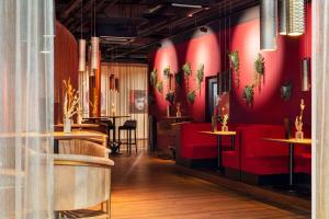 a restaurant with red walls and red chairs at Amedia Plaza Speyer, Trademark Collection by Wyndham in Speyer