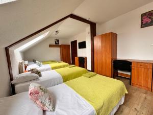 a bedroom with three beds with yellow sheets at Villa Beata in Nowy Sącz