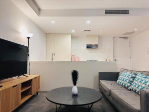- un salon avec un canapé et une table dans l'établissement Cityscape Oasis Homes at Toowong Precinct, à Brisbane
