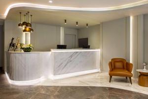 a lobby with a reception desk and a chair at Days Inn by Wyndham Istanbul Bomonti in Istanbul
