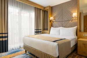 a bedroom with a large bed and a large window at Days Inn by Wyndham Istanbul Bomonti in Istanbul