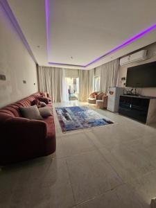 a living room with a couch and a flat screen tv at Sky2030Group in Dammam