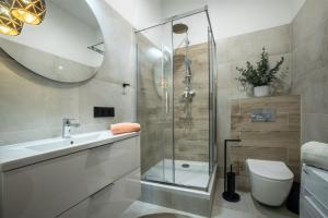 a bathroom with a shower and a sink and a toilet at Apartament Próchnika 9 in Łódź