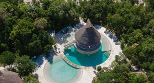 einen Blick über einen Pool mit einer Insel im Wasser in der Unterkunft VILLA PRINCE, loft & rooftop, private pool & jaccuzi RIVIERA MAYA in Puerto Morelos