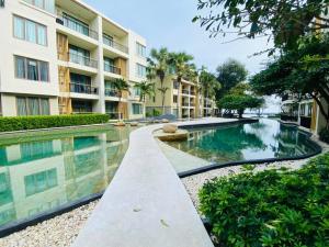a swimming pool in front of a building at 2 Bedroom oceanfront condo in Hua Hin