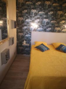 a bedroom with a bed with two pillows on it at Chambre La Palmeraie village naturiste in Cap d'Agde