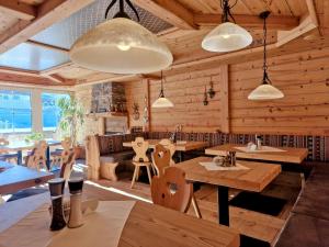 un restaurante con paredes de madera, mesas y luces en Berghotel Almrausch, en Berwang