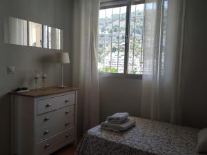 1 dormitorio con 1 cama con tocador y ventana en Luz de Tropicana en La Herradura